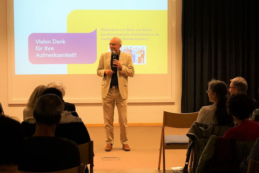 Ein Mann hält einen Vortrag vor vielen Zuhörern Ein Mann hält einen Vortrag vor vielen Zuhörern